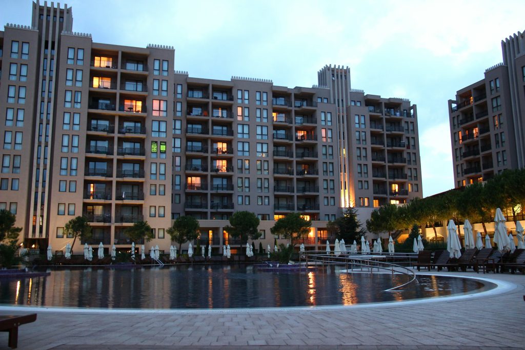 Image of an apartment courtyard with a pool. Apartments look down onto a clear water pool